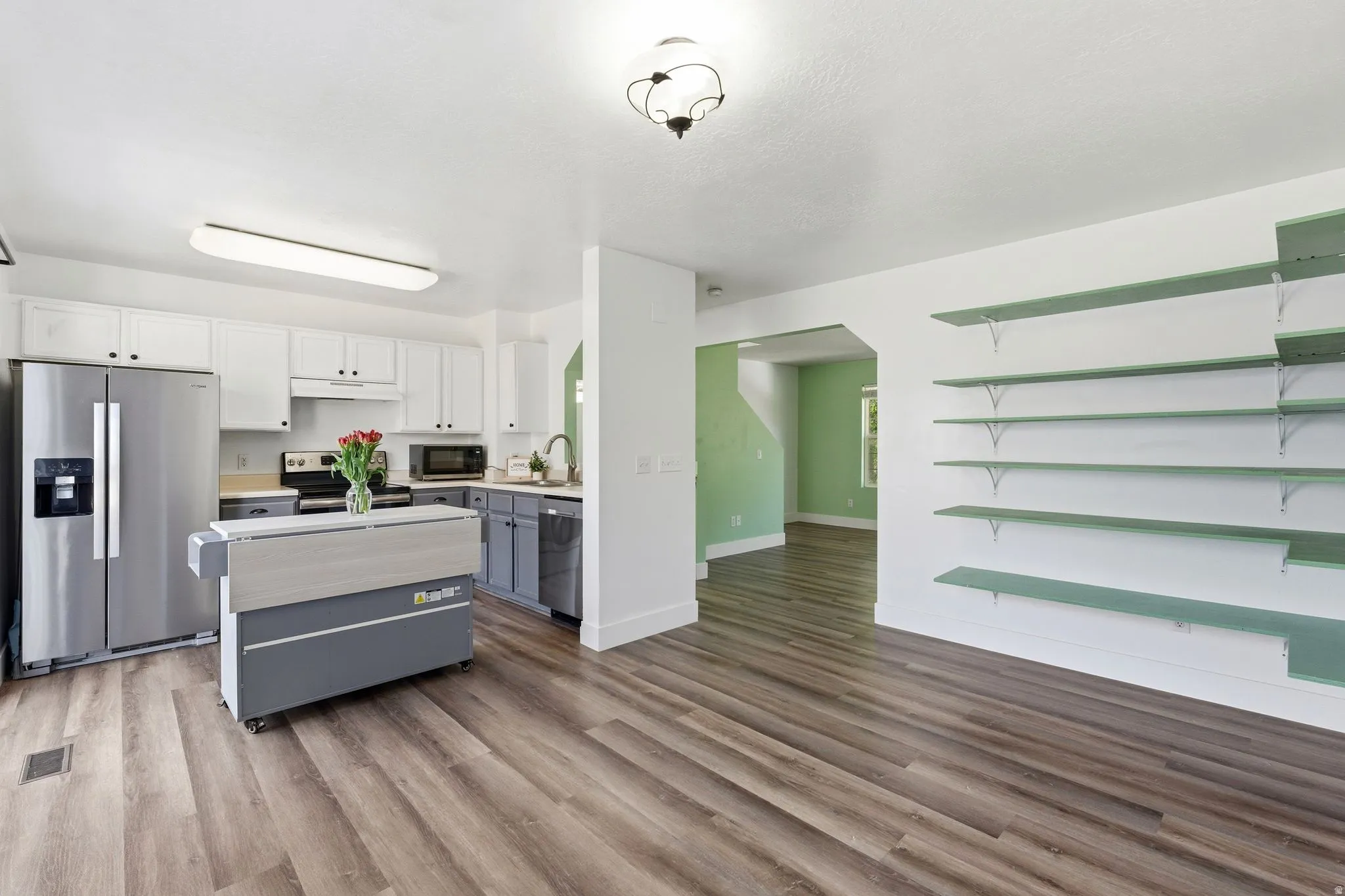 Open-concept kitchen and living area featuring wood-finish flooring