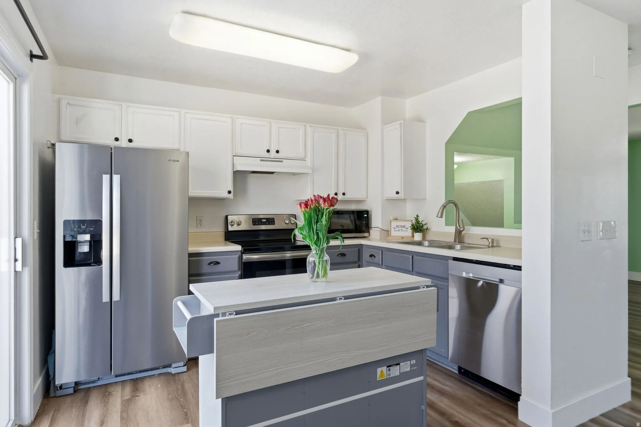 Well-appointed kitchen featuring a stainless steel refrigerator, dishwasher, and range