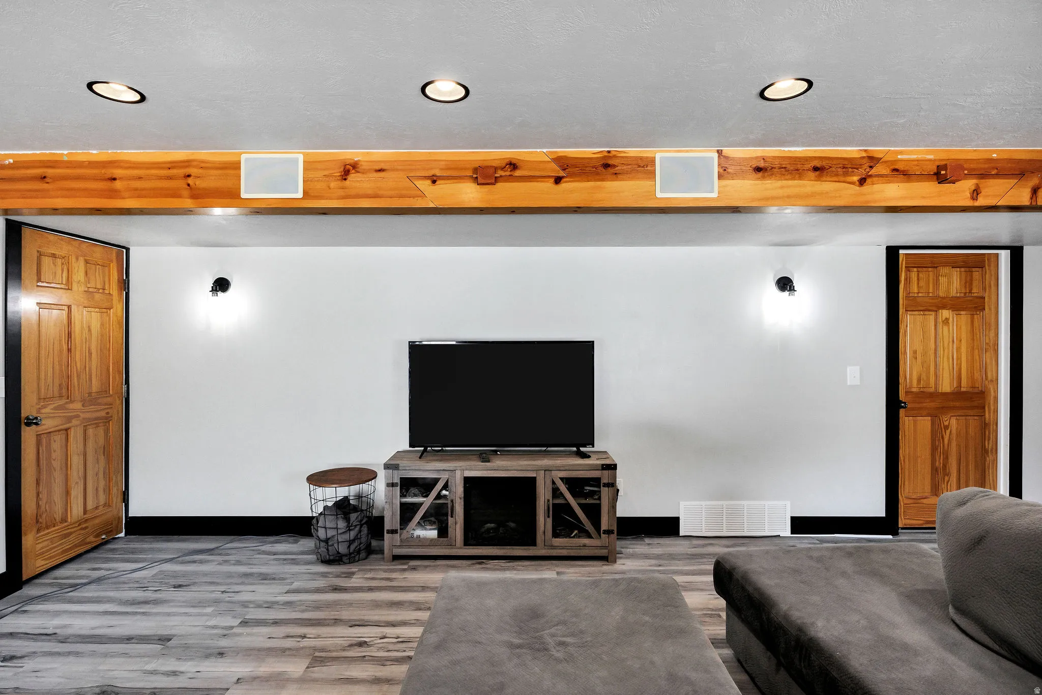 Living area featuring a prominent wood beam with recessed lighting and integrated speakers