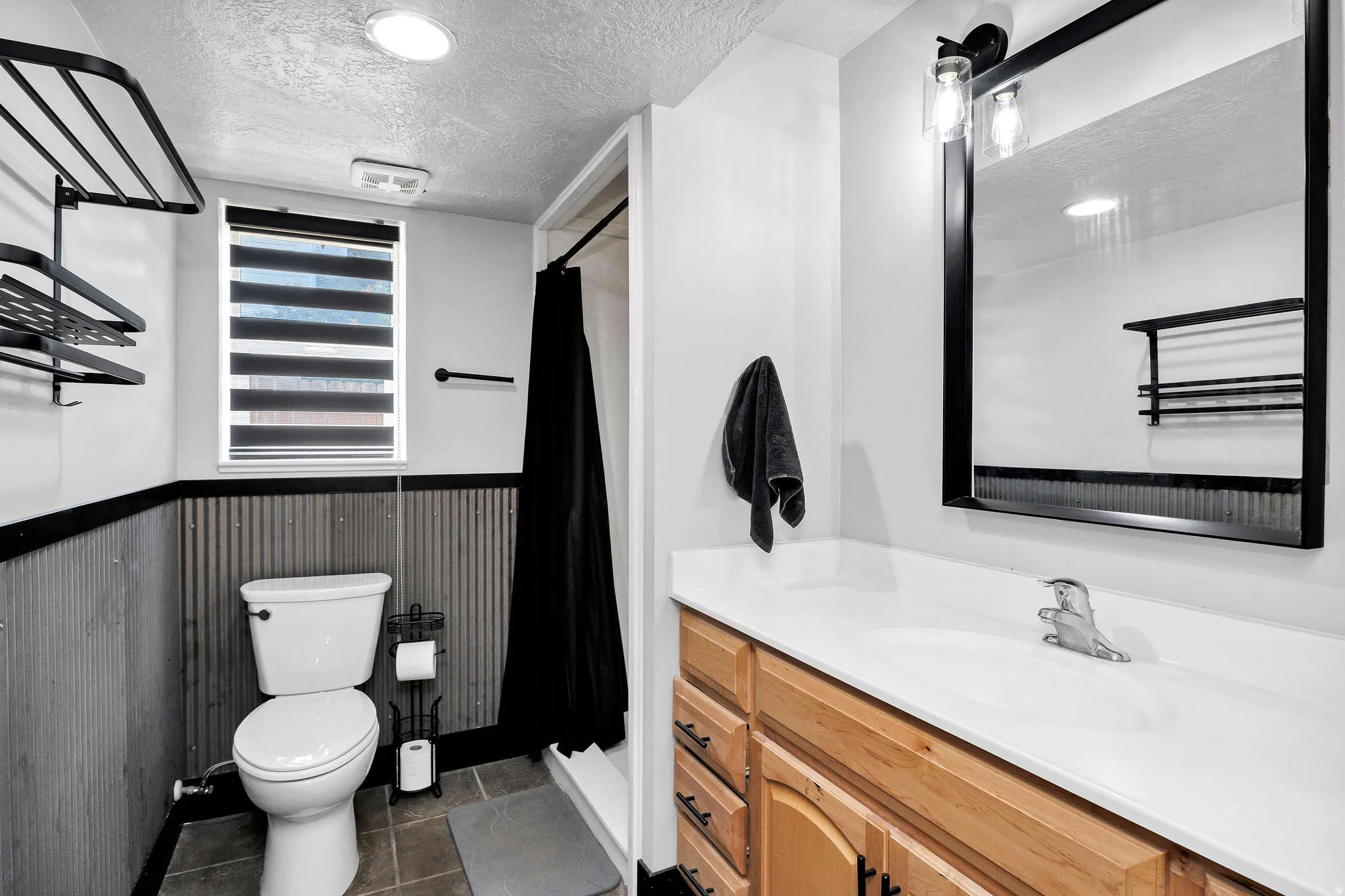 Bathroom featuring a light wood-finish vanity with a white countertop and integrated sink