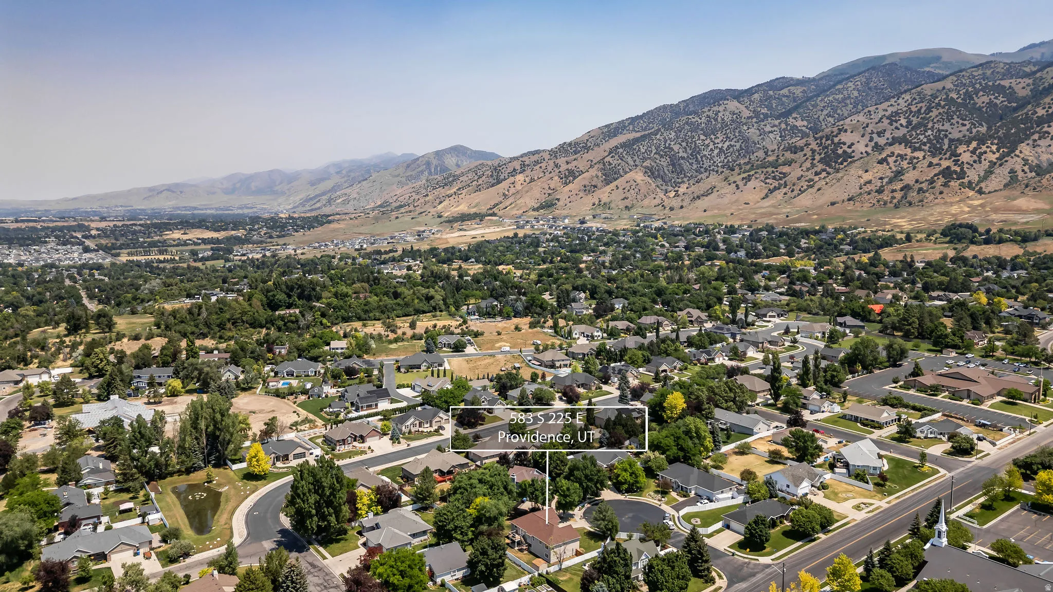 Aerial perspective showcasing a residential neighborhood against a mountain backdrop