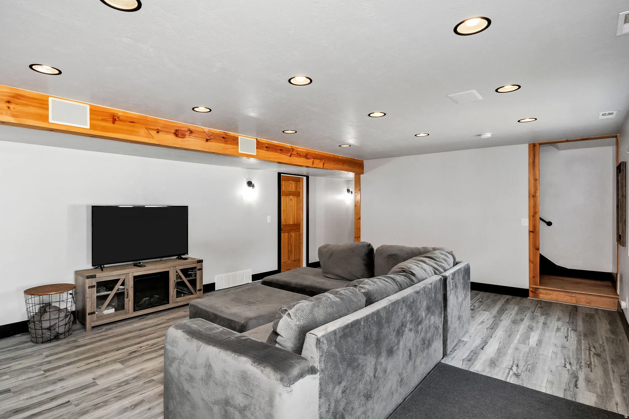 Spacious common area featuring wood-finish flooring, recessed lighting, and exposed wood beams