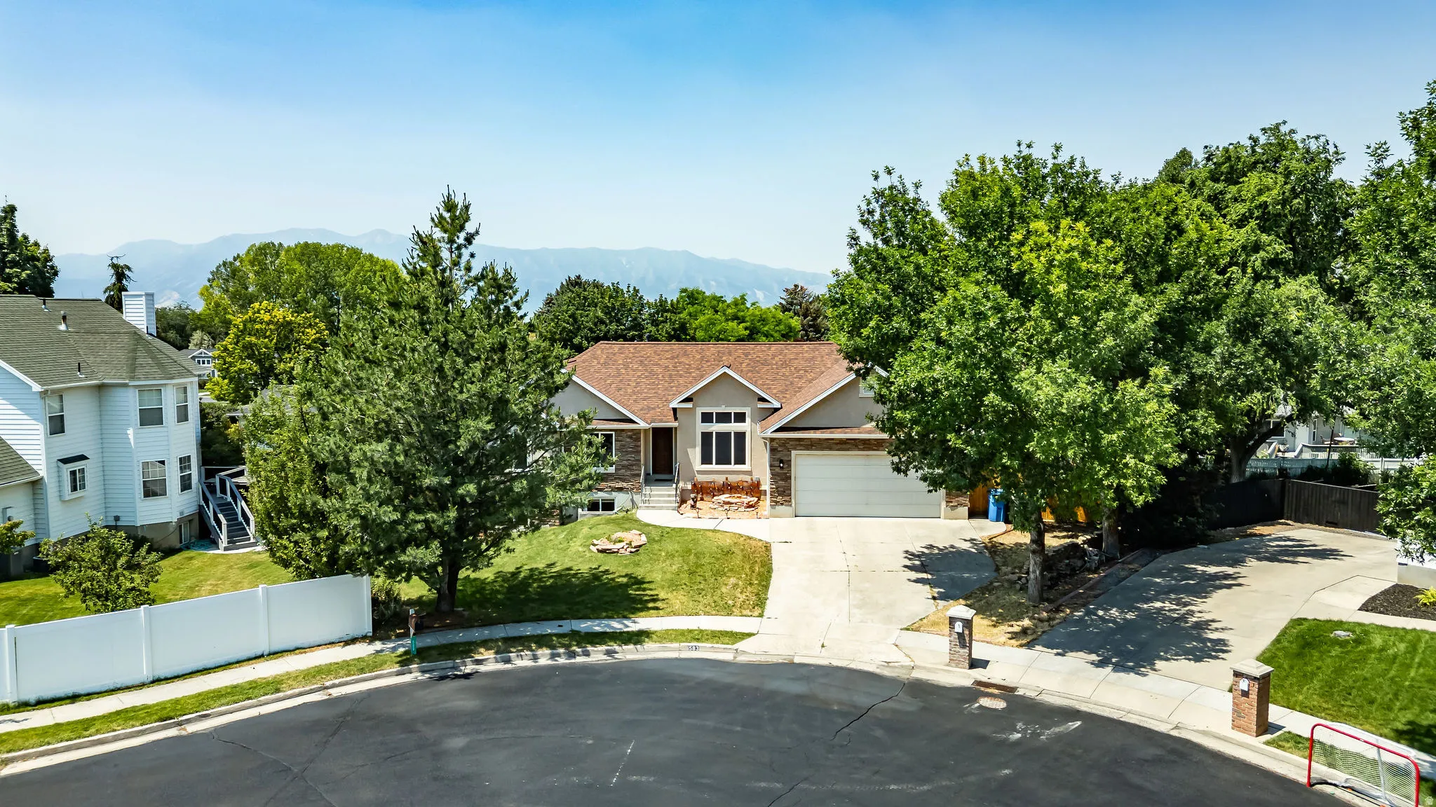 Single-story residence featuring a two-car garage, concrete driveway, and a shingle roof
