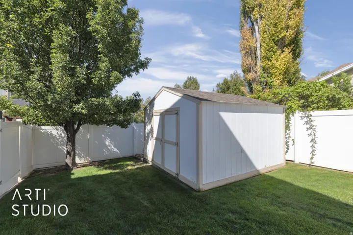 Detached storage shed with a shingled roof and double doors