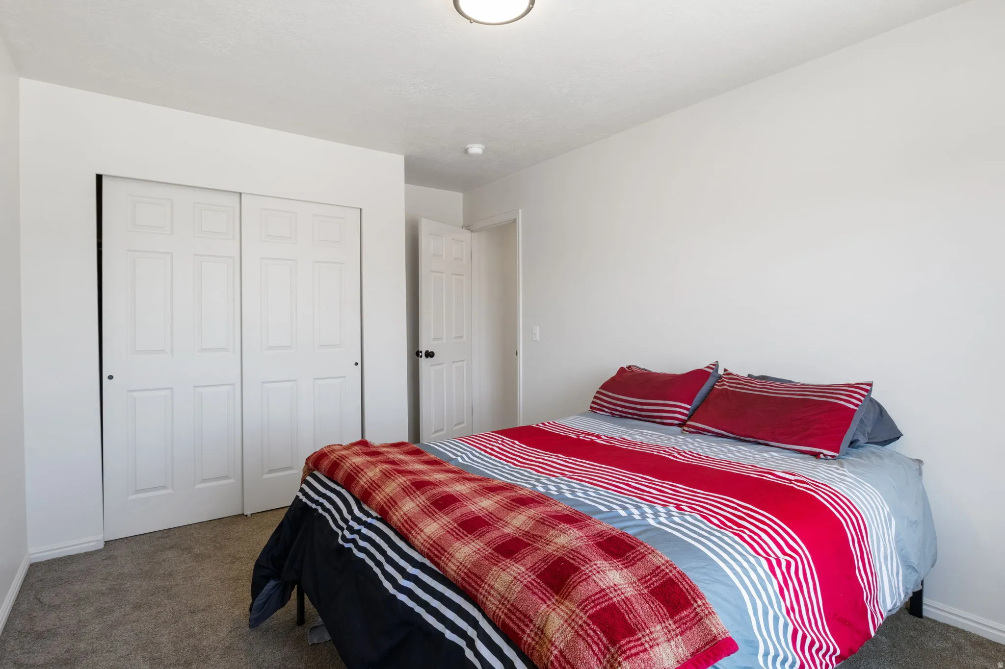 Bedroom with neutral wall paint, gray carpet flooring, and a flush mount ceiling light