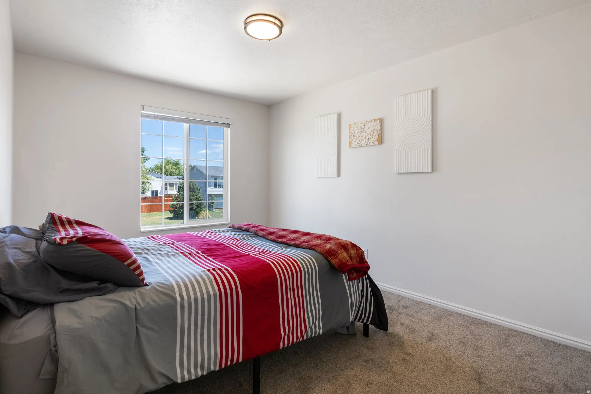 Room featuring a large window, neutral wall paint, and textured carpeting