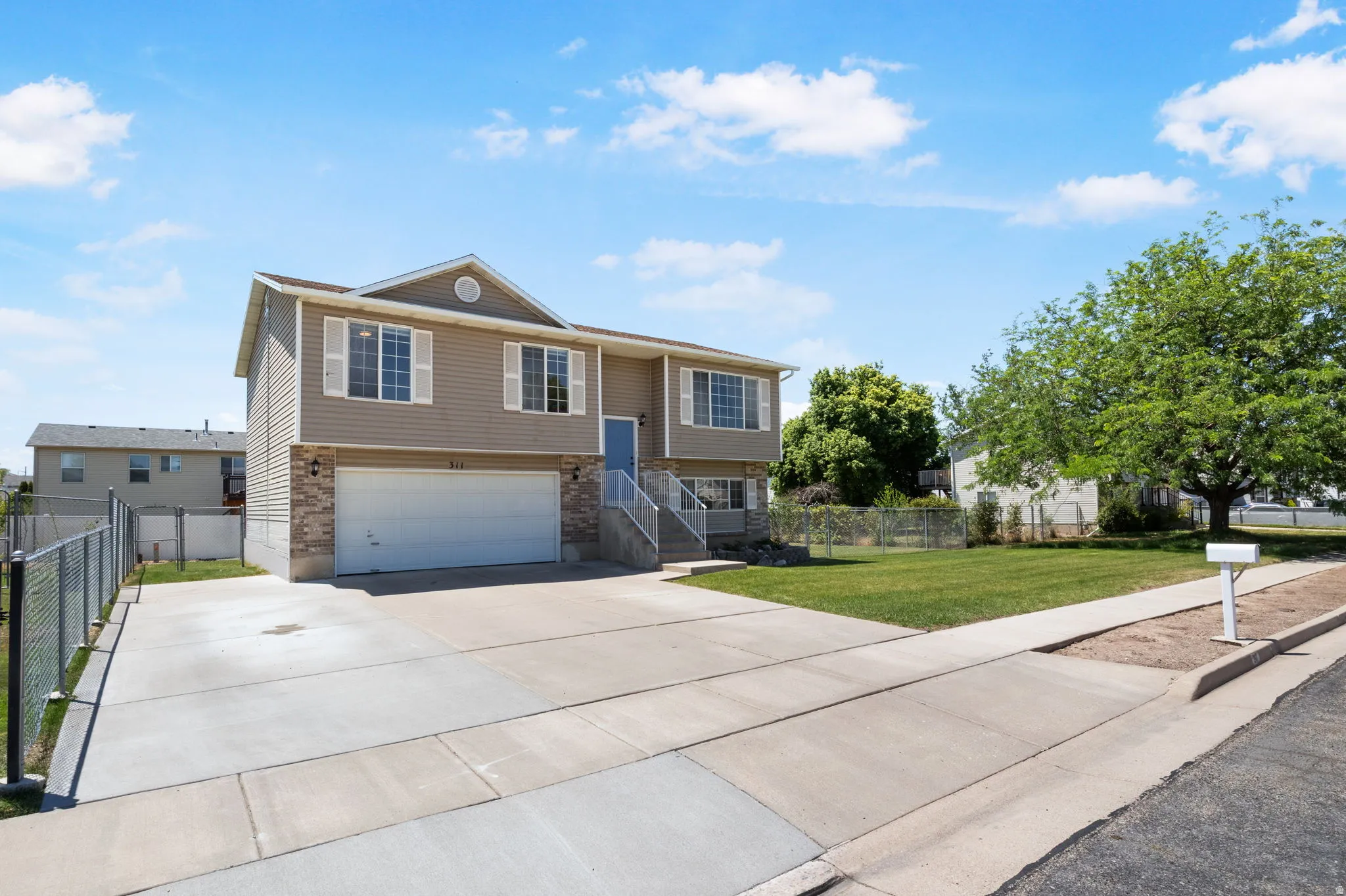 Split-level residence featuring a two-car garage with a concrete driveway