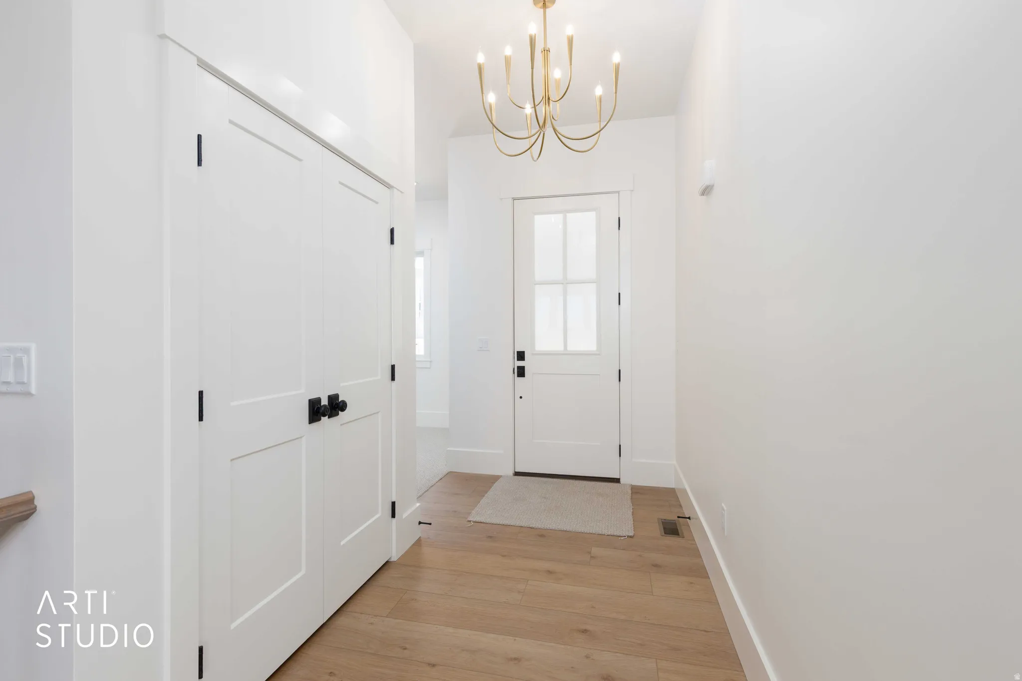 Foyer with light wood-finish flooring and white walls