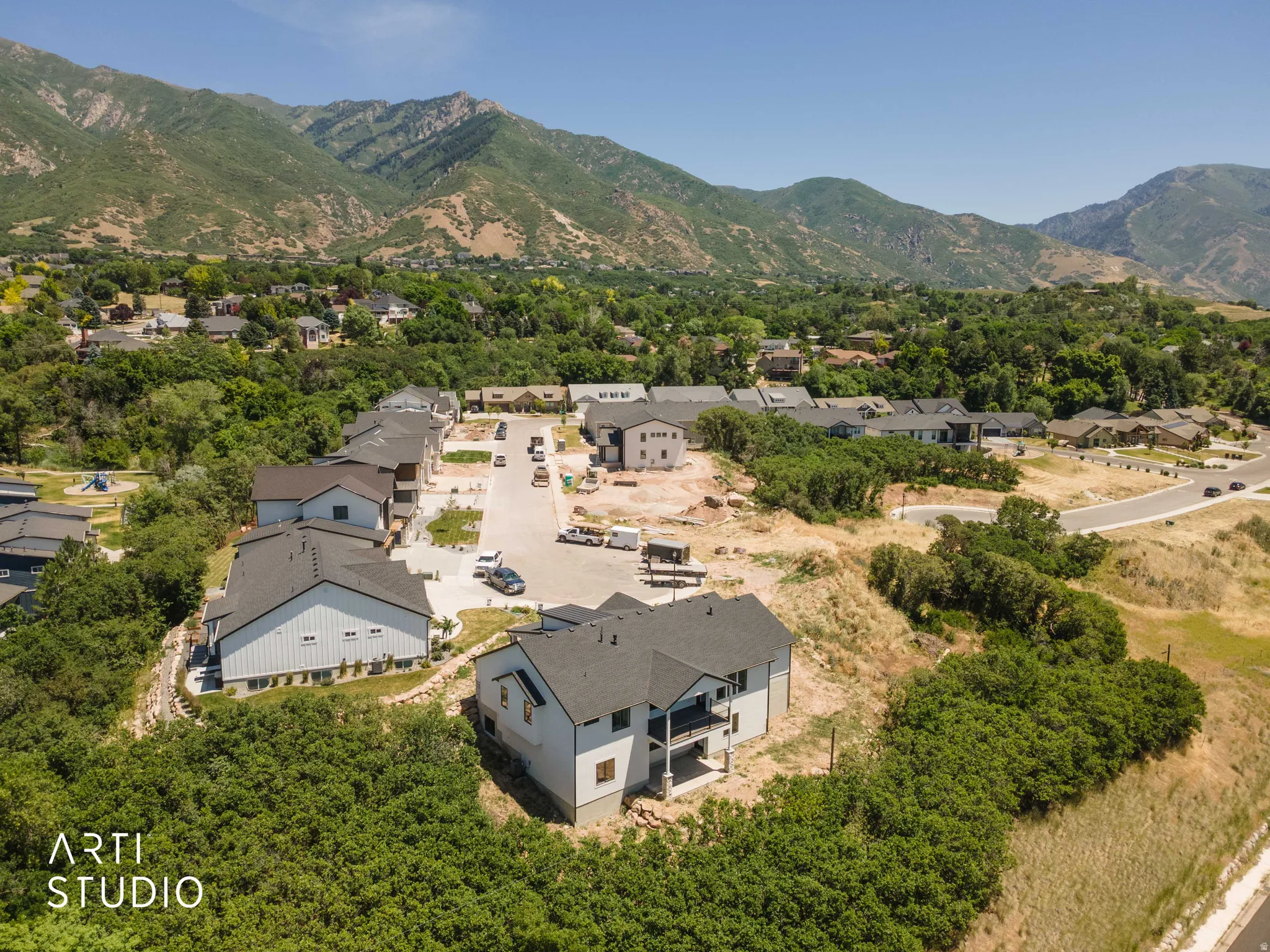 Newly constructed residential development featuring modern homes with dark roofs and light siding