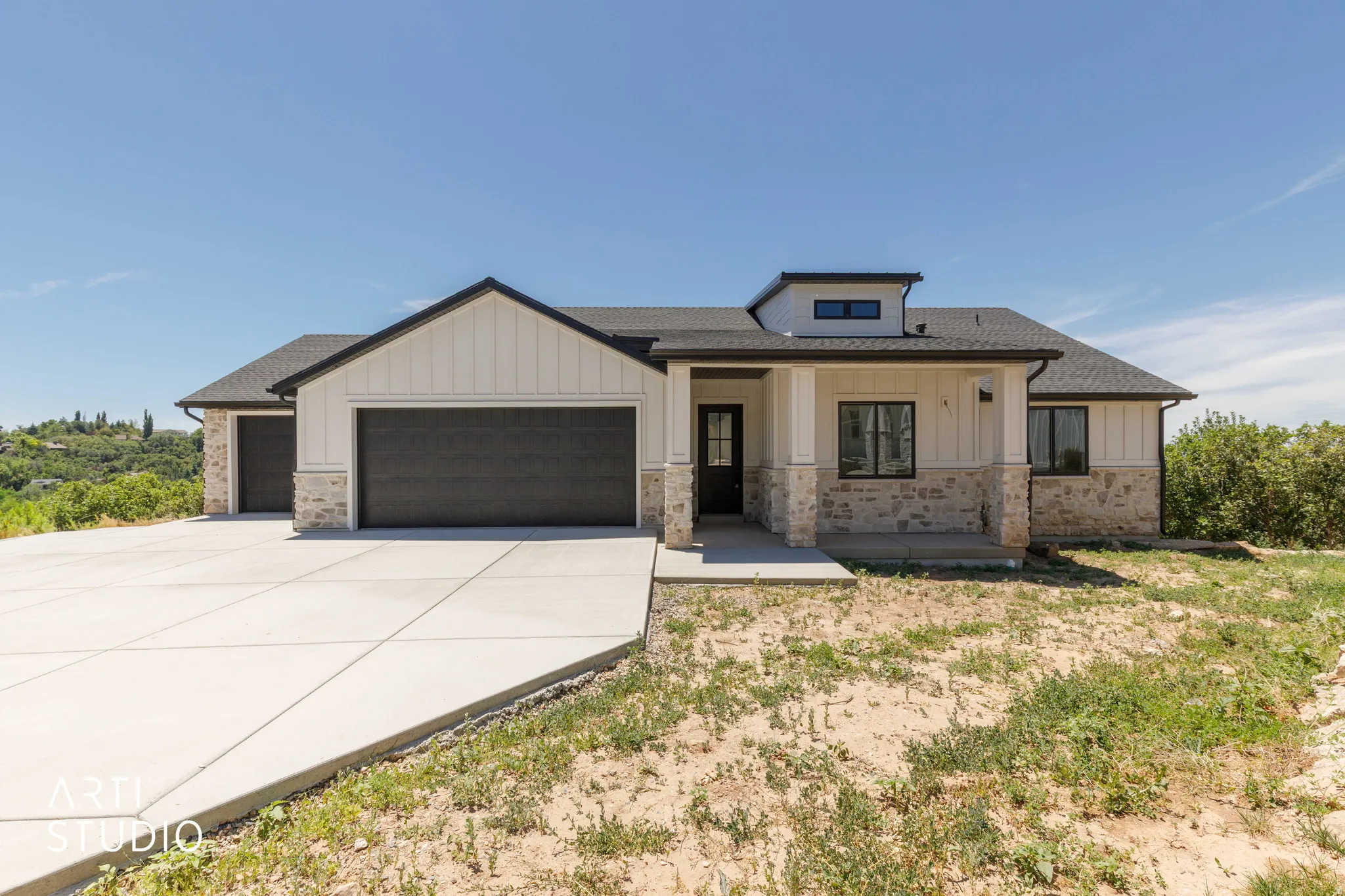 Contemporary home featuring a dual-tone exterior with light siding and stone accents