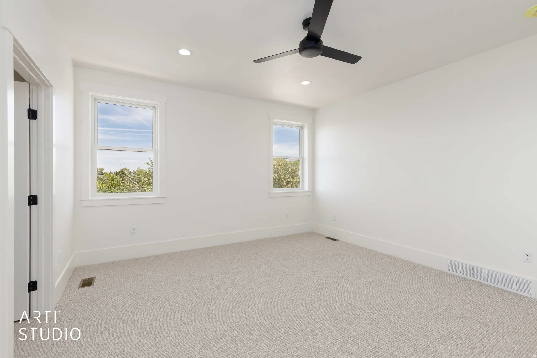 Neutral-toned carpeting complements the white walls and trim in this room