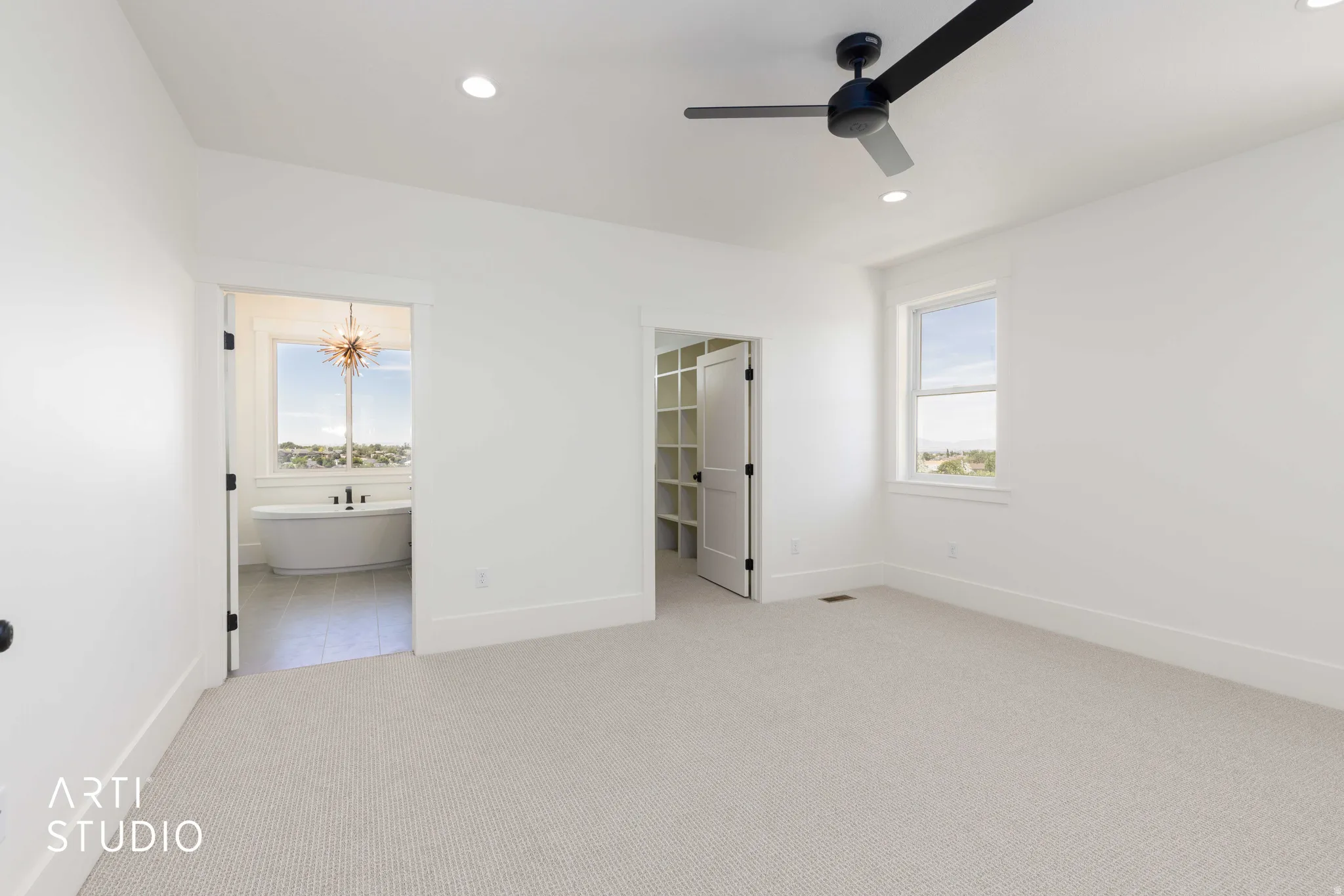 Spacious room with light-colored carpeting and white walls
