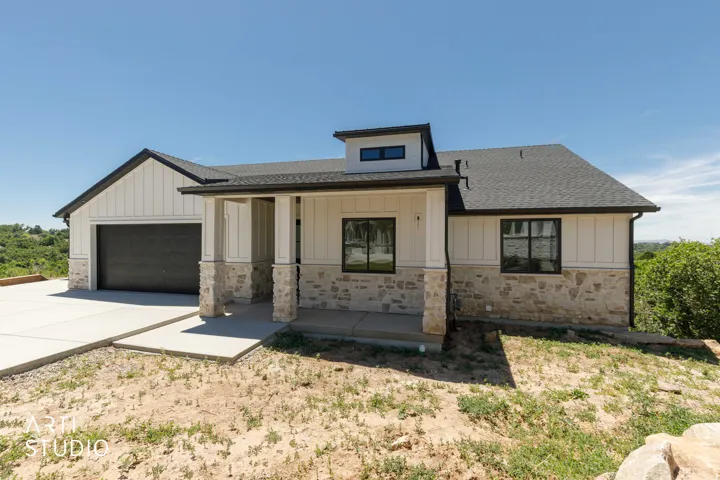 Modern ranch-style home featuring a stone and vertical siding facade