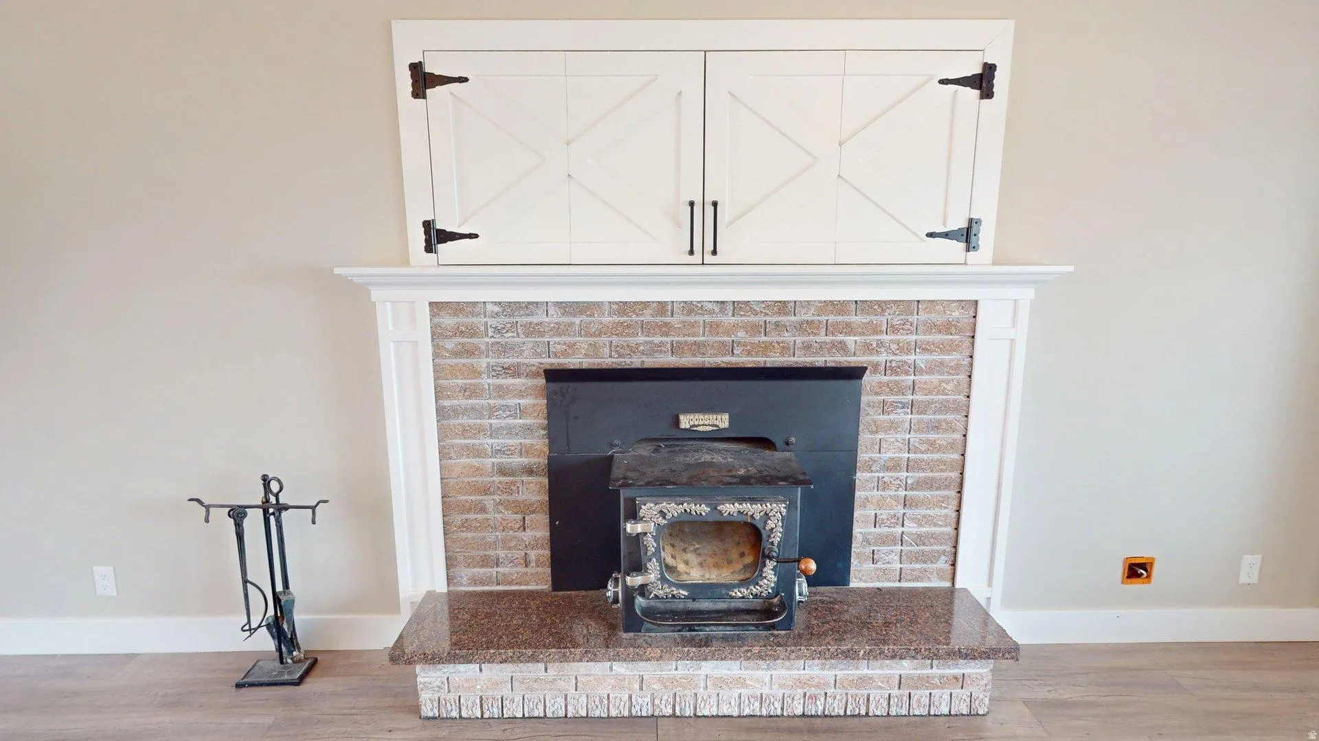 Fireplace featuring a brick surround, granite hearth, and wood-burning stove