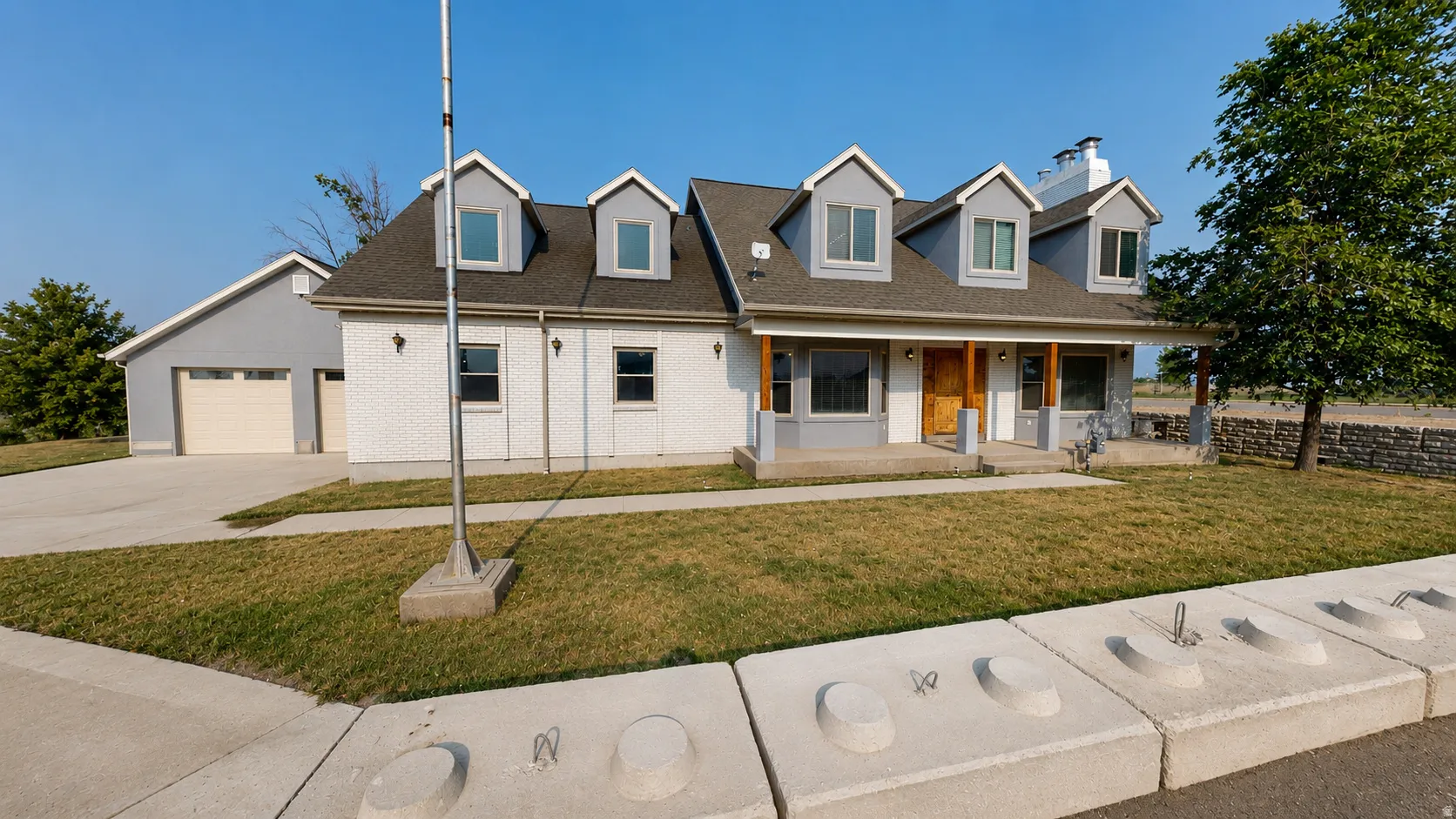 Ai enhanced photo. White brick facade with gray dormers and a covered front porch featuring wood support beams