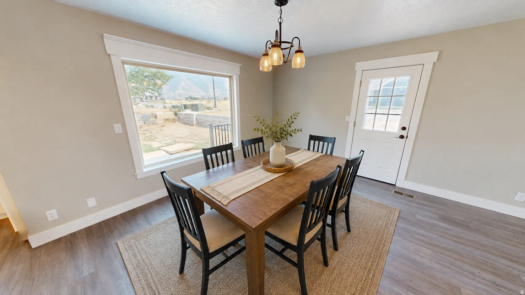 Ai enhanced photo. Dining area featuring a prominent window, wood-finish flooring, and a glass-paneled exterior door