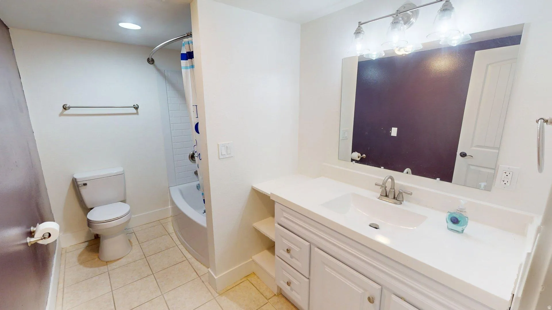 Bathroom featuring a white vanity with an integrated sink, brushed nickel faucet, and a large wall-mounted mirror
