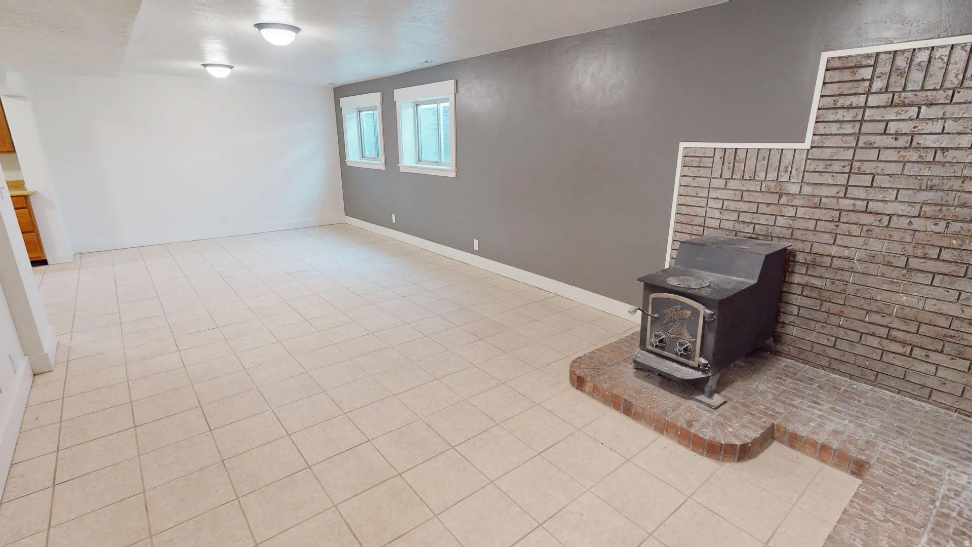 Spacious living area featuring light-toned tile flooring throughout