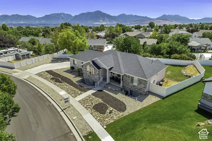 Contemporary residence featuring a stone and siding exterior, a dark shingle roof, and a concrete driveway