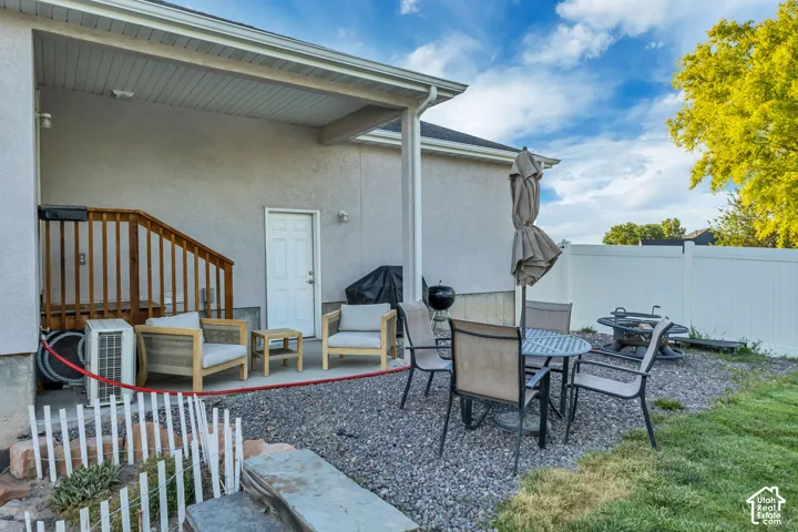 Covered patio area featuring a concrete pad and gravel landscaping