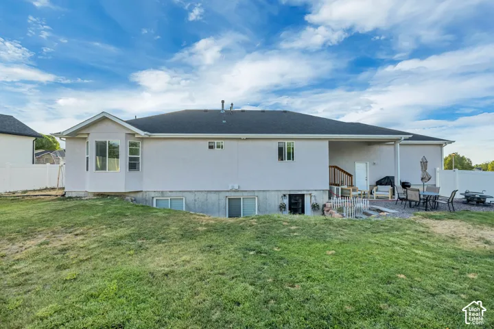 Expansive sloped lawn area with a stone patio