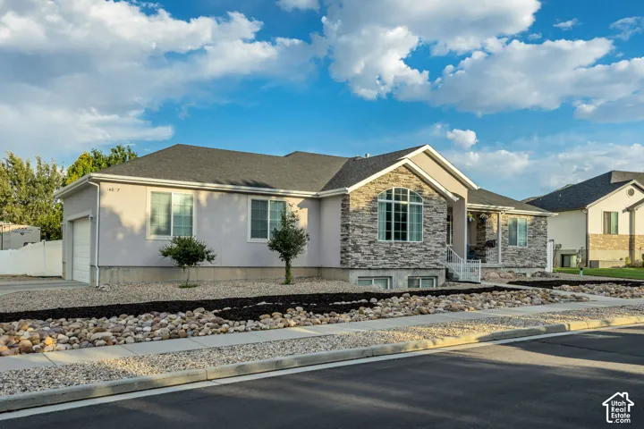 Ranch-style residence featuring stone veneer and stucco exterior finishes