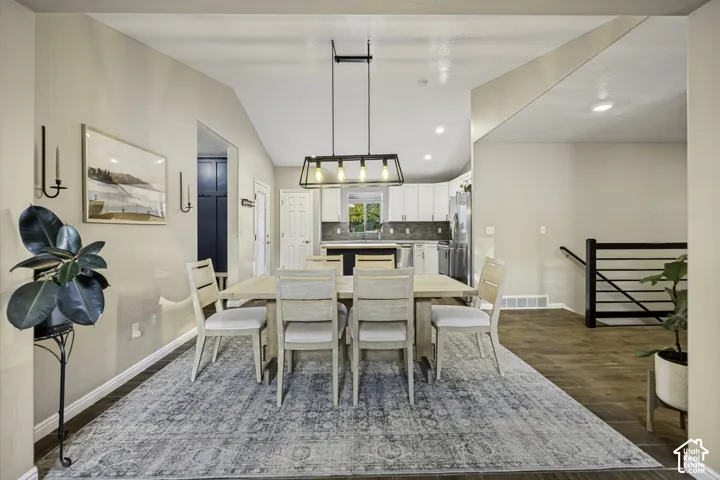 Dining area featuring a vaulted ceiling and a contemporary linear chandelier
