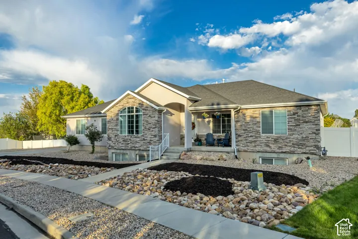 Contemporary ranch-style home featuring a stone and stucco exterior