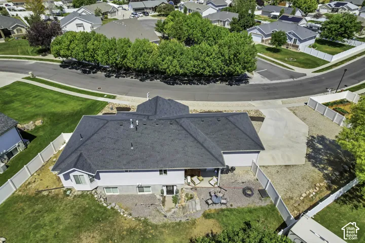Aerial perspective showcasing a single-family residence with a dark shingle roof, a two-car garage, and a concrete driveway
