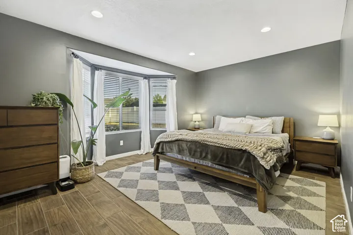 Bay window featuring louvered blinds and sheer curtains