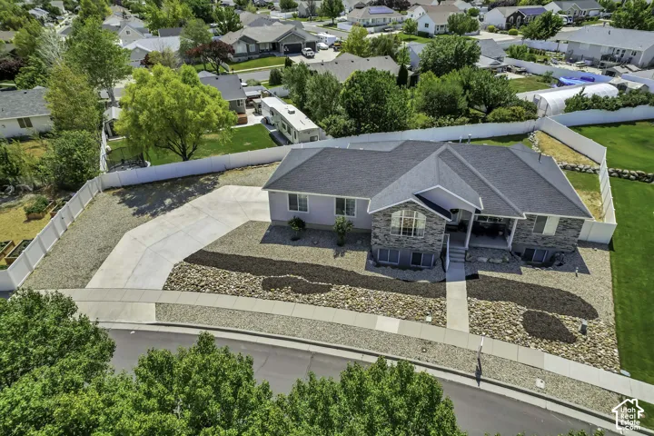 Split-level residence featuring a gray shingle roof and a combination of light siding and stone veneer