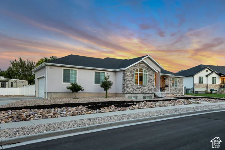 Ranch-style residence featuring a stone facade and stucco exterior