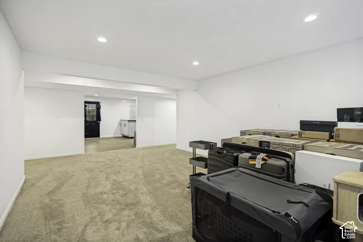 Spacious room featuring neutral carpeting and recessed lighting