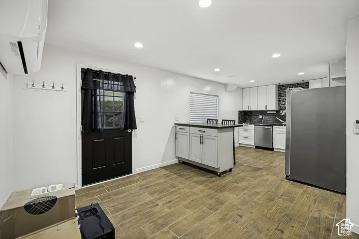 Open-concept living area with wood-finish tile flooring