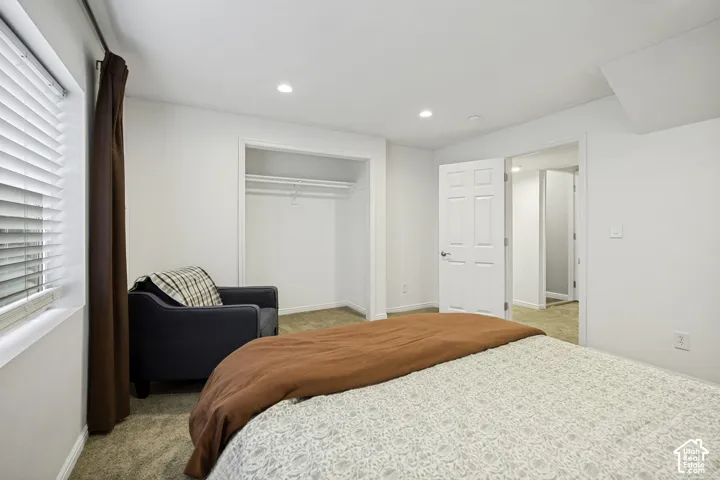 Carpeted room with recessed lighting and an open closet
