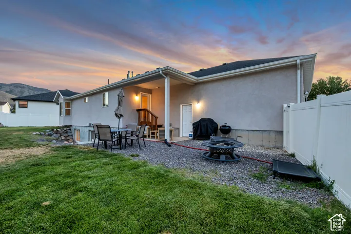 Spacious backyard featuring a covered patio, gravel landscaping, and a manicured lawn