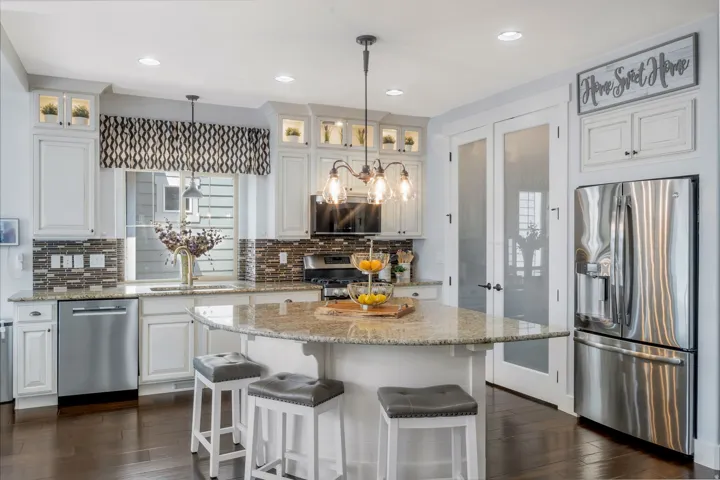 Kitchen featuring white cabinetry, a central island with a light-toned countertop, and stainless steel appliances