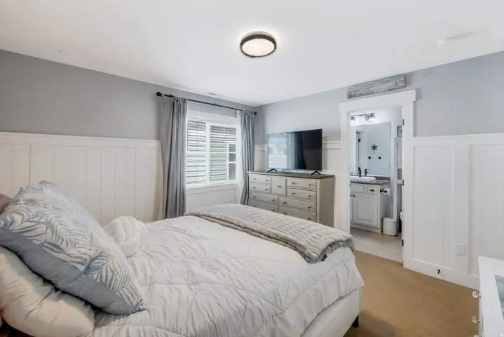 Bedroom featuring white wainscoting and light gray walls