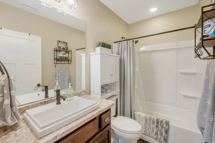 Bathroom featuring a white rectangular vessel sink, brown wood-finish vanity, and a light-colored countertop