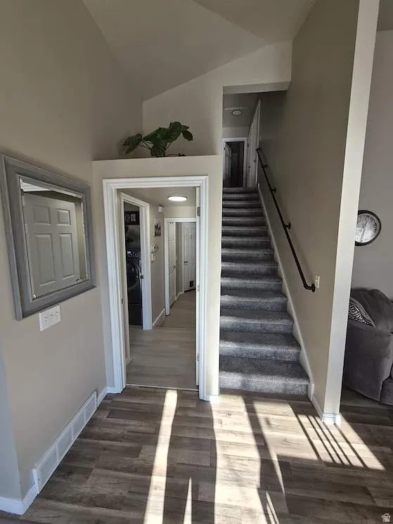 Vaulted ceilings complement the wood-finish flooring and carpeted staircase