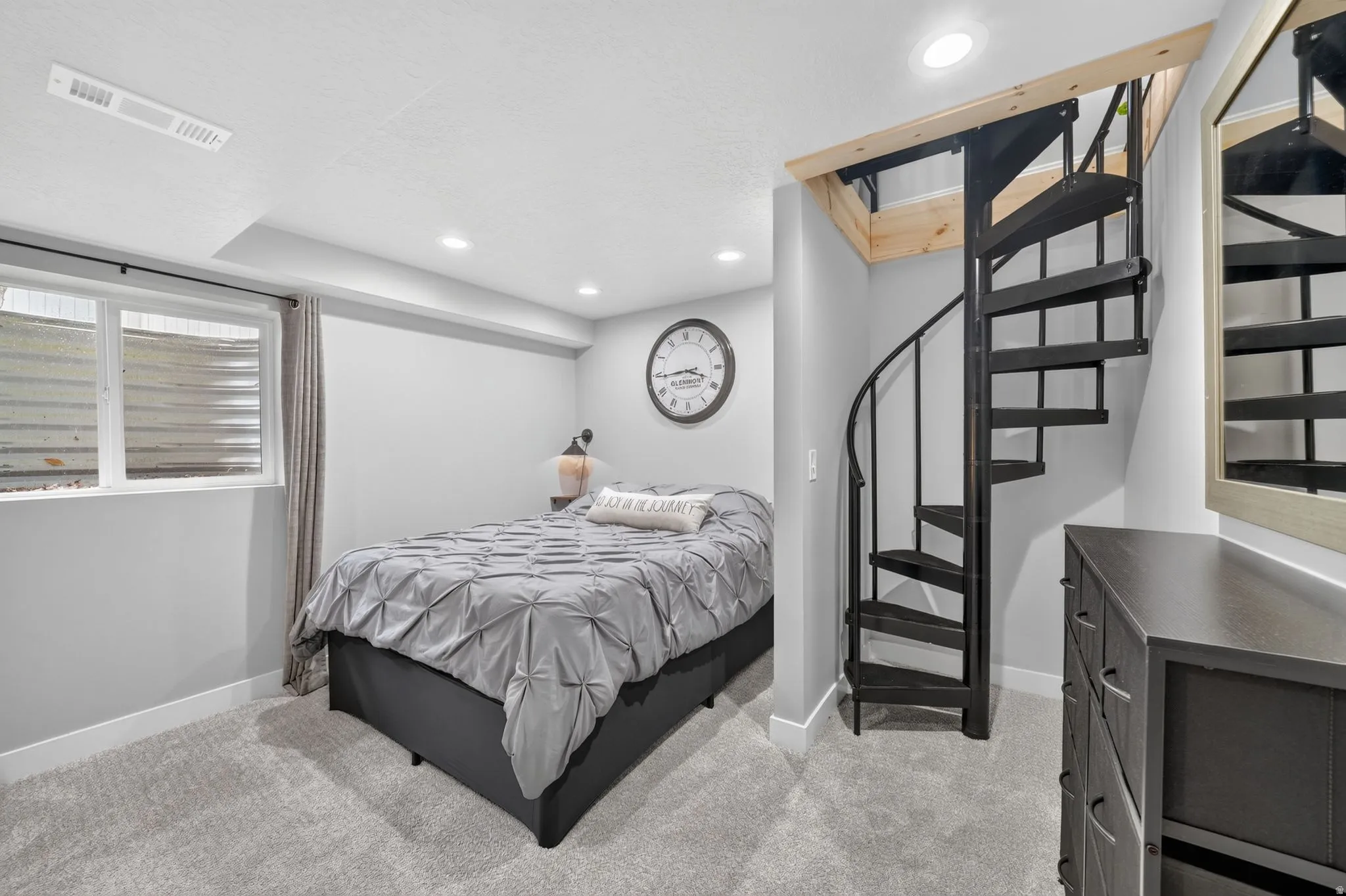 Spiral staircase with black metal construction and natural wood framing
