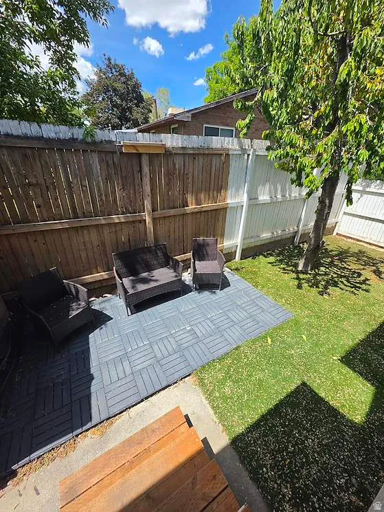 Backyard featuring a modular paver patio area and a manicured lawn