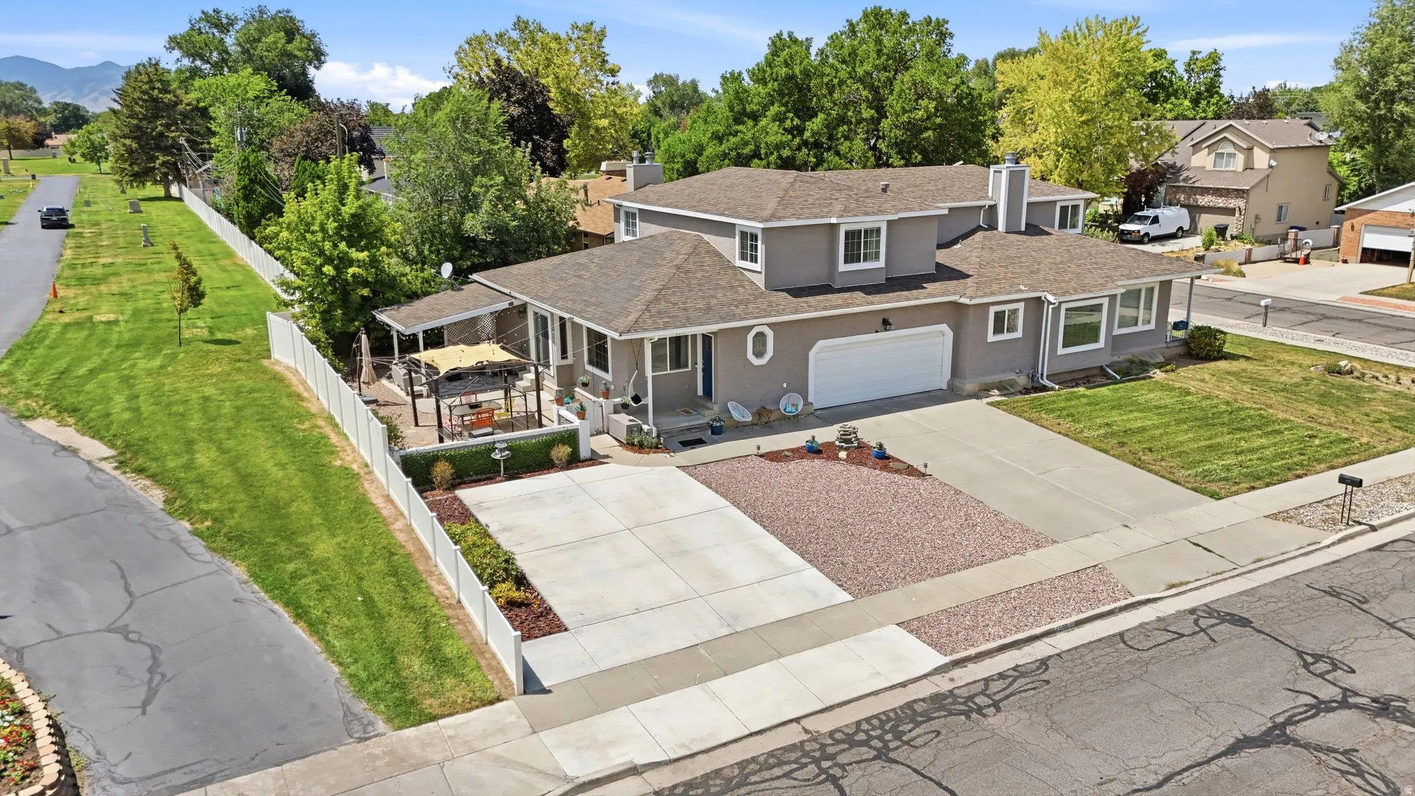 Contemporary two-story residence featuring a two-car garage, expansive concrete driveway, and a gravel accent area