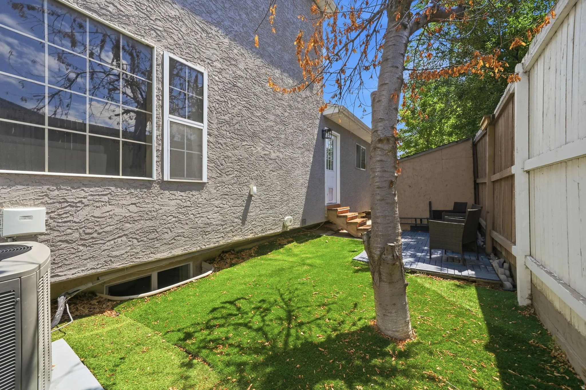 Private backyard featuring artificial turf, a paver patio area, and a wood fence