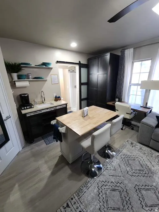 Open-concept living area featuring light wood-finish flooring, recessed lighting, and a ceiling fan