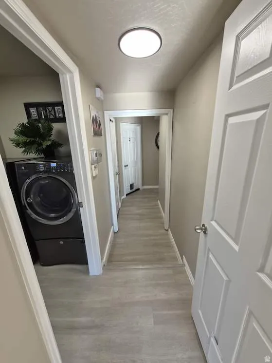 Hallway featuring light wood-finish flooring and neutral wall tones