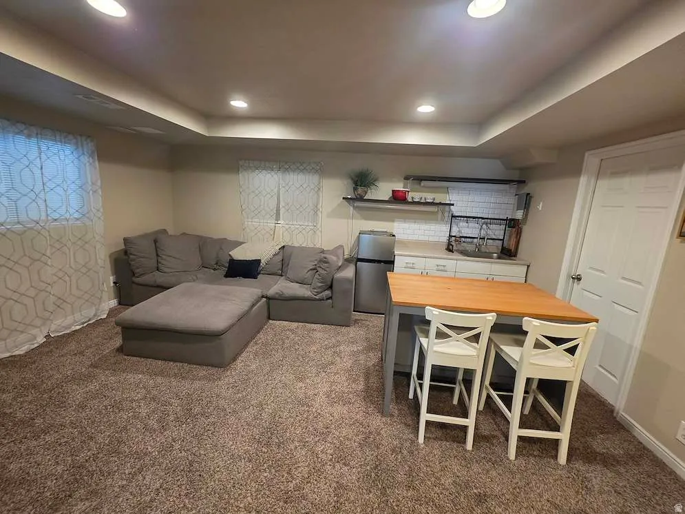 Recreational space featuring recessed lighting, a compact kitchenette with white subway tile backsplash, and a built-in shelf