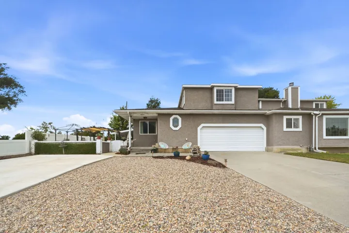 Stucco exterior with white trim, an attached garage, and a concrete driveway