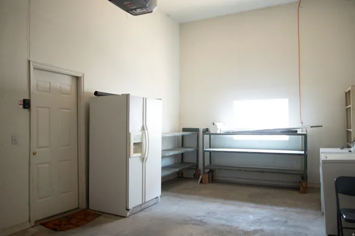 Utility space featuring a concrete floor, high ceilings, and a paneled interior door