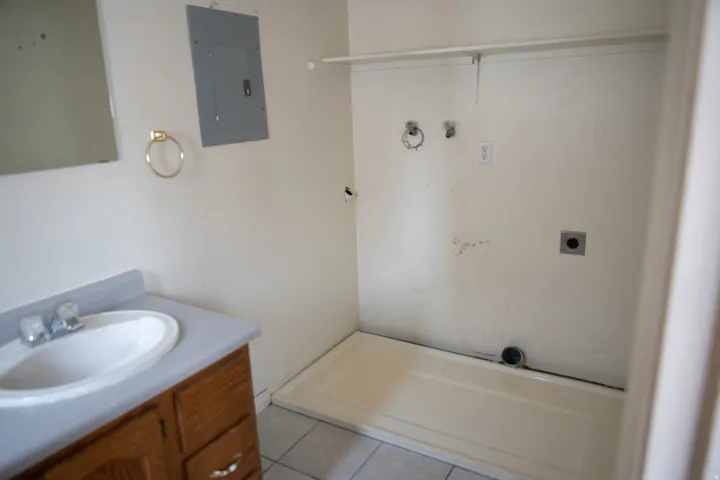 Utility area featuring a laundry hookup, electrical panel, and tile flooring